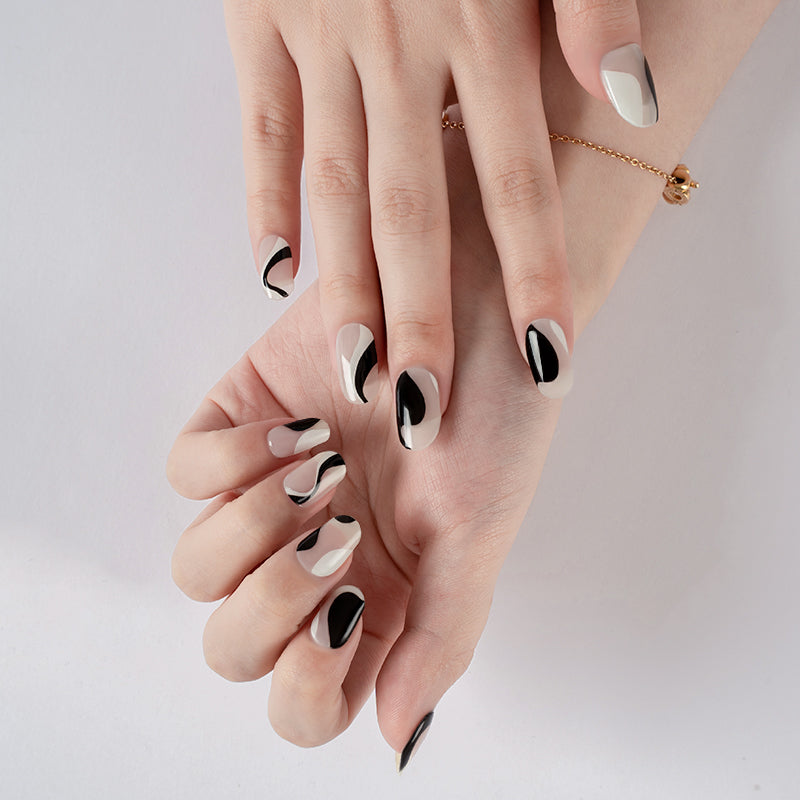 Modern black and white graphic nails on hands, featuring minimalist line art achieved with a DIY semi-cured gel sticker kit.