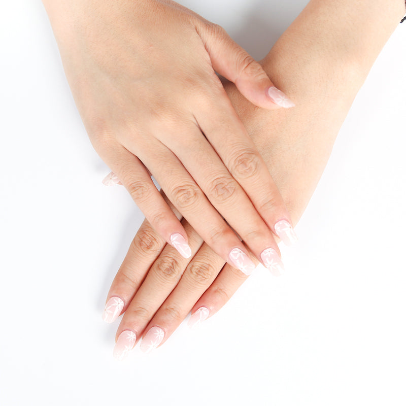 Elegant blush and ivory bridal nails with delicate white blossom designs on natural hands, achieved with a DIY semi-cured gel sticker kit.