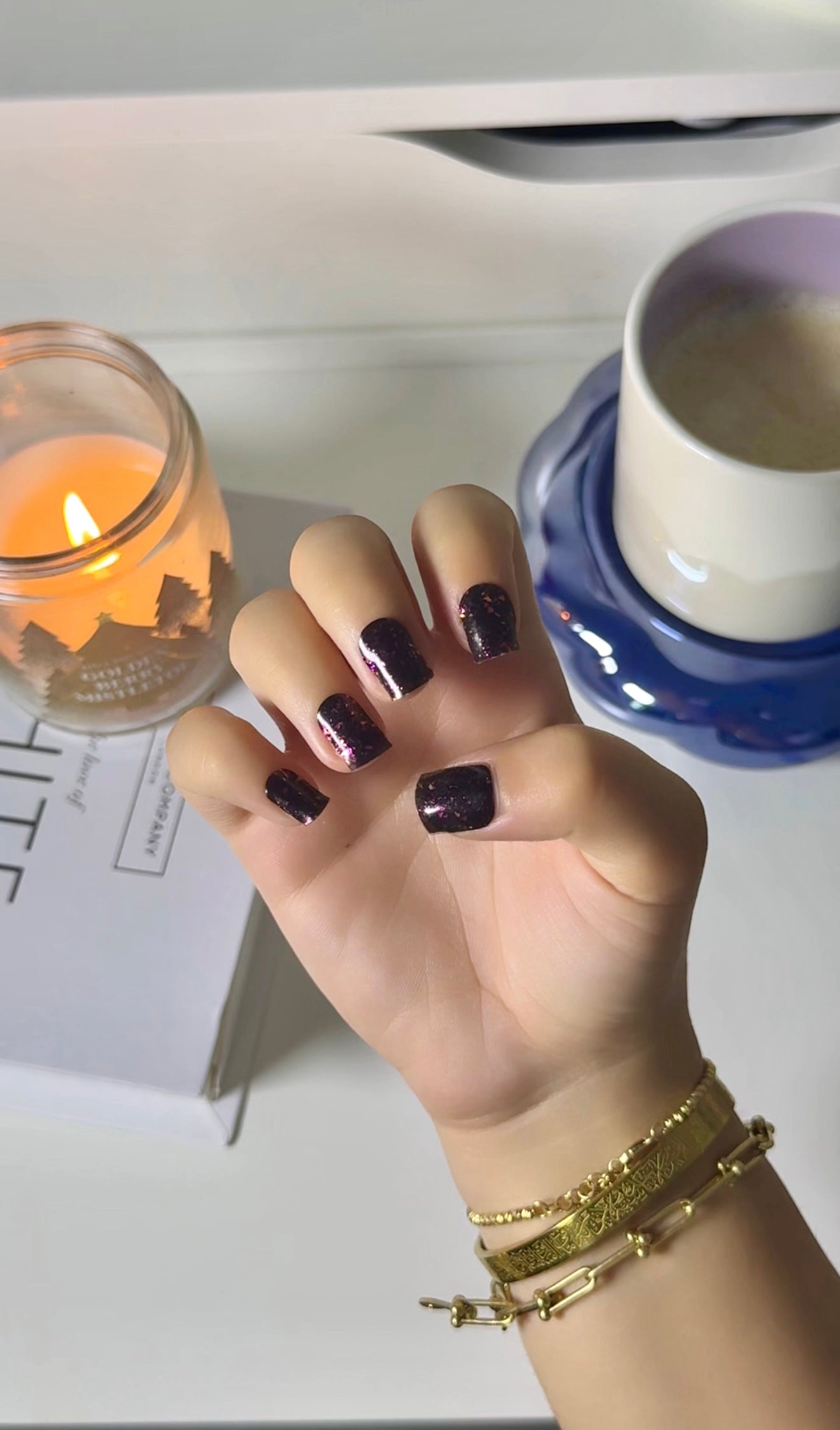 Elegant gold fleck nails on natural hands, achieved with a DIY semi-cured gel sticker kit for a sparkling, salon-quality manicure at home.